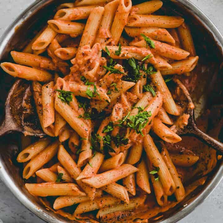 A plate of Penne alla Vodka garnished with fresh basil